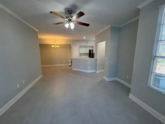 en empty room with windows and ceiling fan