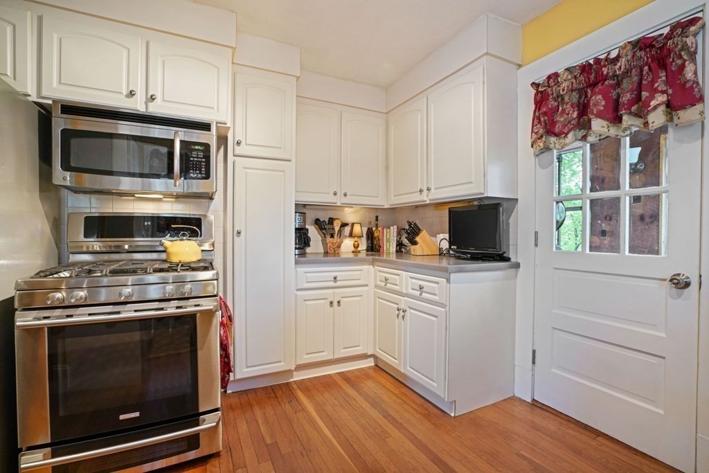 54 Olney Street Watertown, MA 02472 - Photo 11 of 28 a kitchen with stainless steel appliances a stove a microwave and cabinets