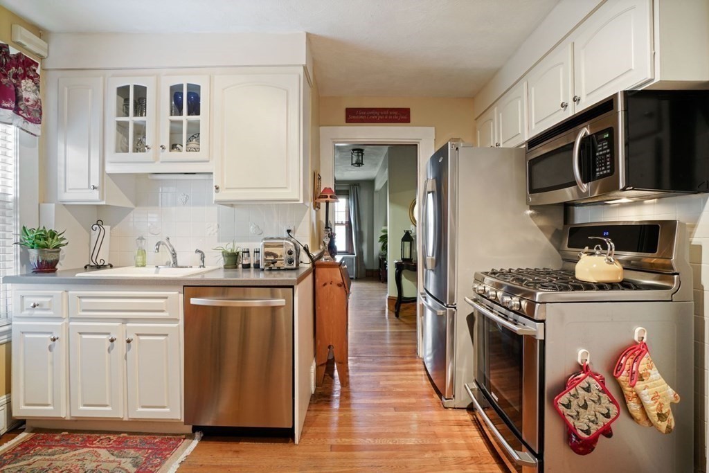 54 Olney Street Watertown, MA 02472 - Photo 13 of 28 a kitchen with stainless steel appliances granite countertop a stove and cabinets