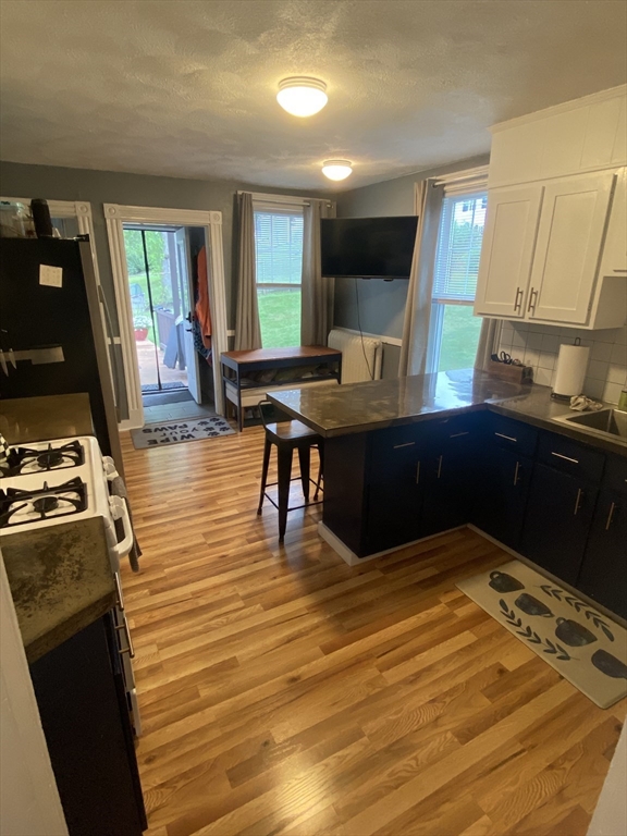 54 Olney Street Watertown, MA 02472 - Photo 3 of 28 a kitchen with stainless steel appliances wooden cabinets and a table