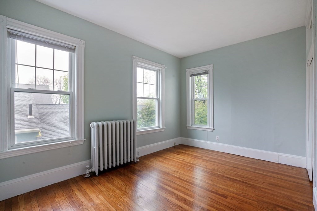 54 Olney Street Watertown, MA 02472 - Photo 9 of 28 a view of an empty room with wooden floor and a window