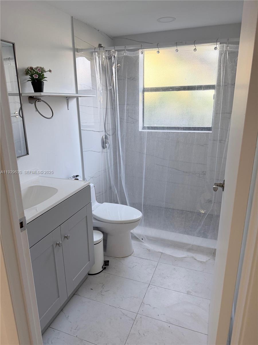 15312 Southwest 72nd Street, Unit 2112 Miami, FL 33193 - Photo 3 of 11 a bathroom with a sink a toilet and shower