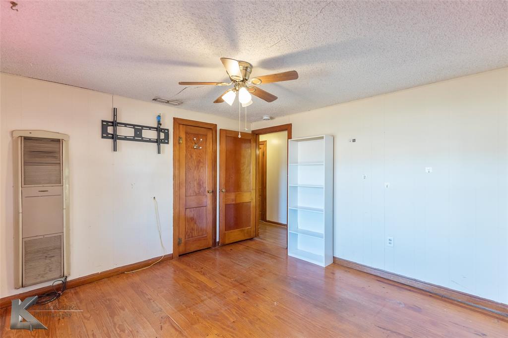 405 South Hinton Street Benjamin, TX 79505 - Photo 6 of 40 Unfurnished bedroom with a heating unit, light wood-style floors, a textured ceiling, and a ceiling fan