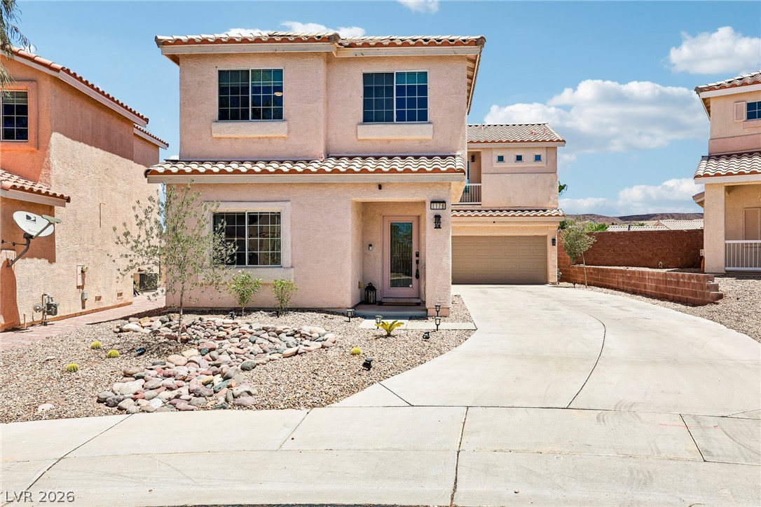 1176 Butternut Ranch Court Henderson, NV 89052 - Photo 2 of 60 A well-maintained desert landscape fronts this inviting residence, featuring an attached garage and a neatly paved driveway.