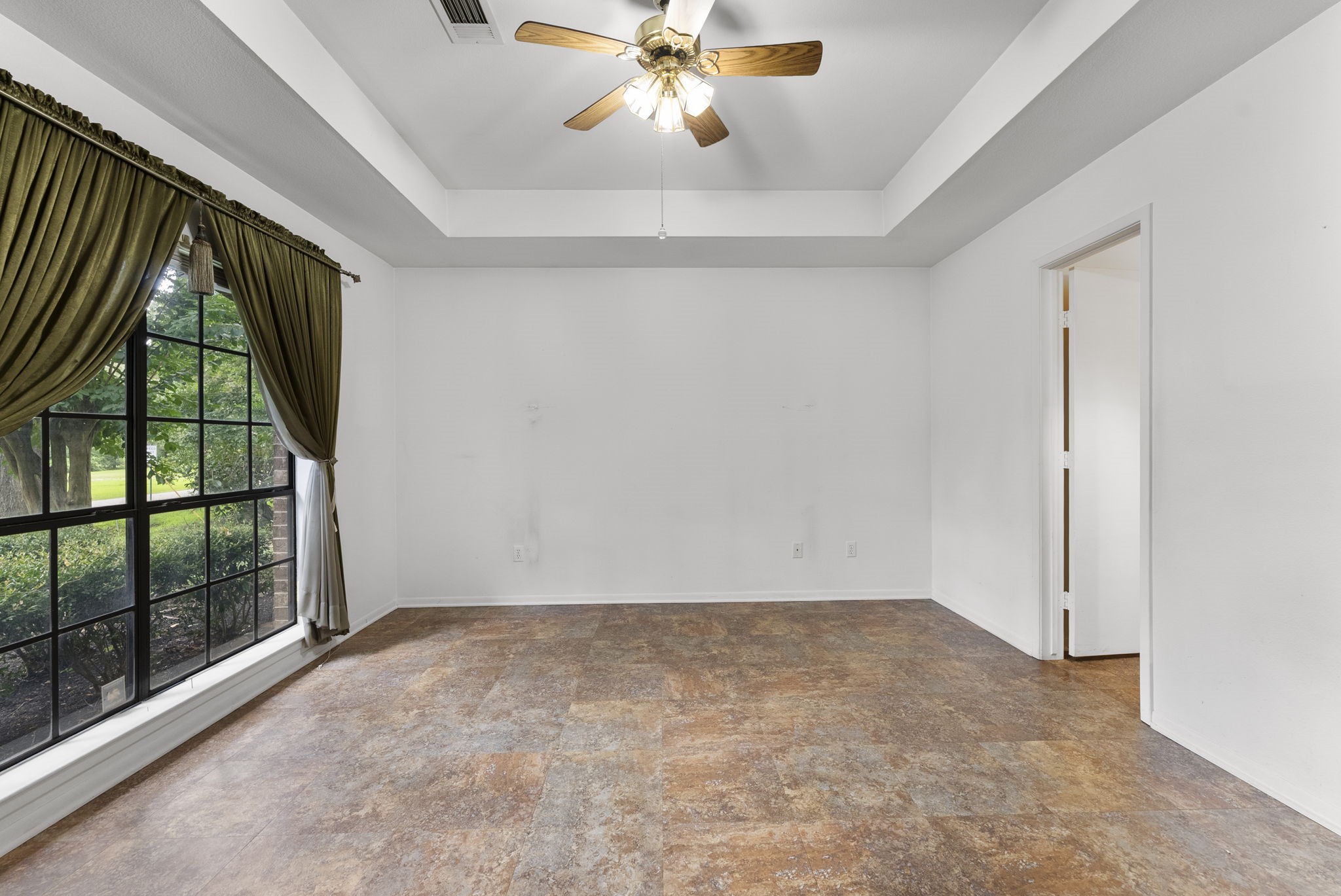 202 Sunset Boulevard Conroe, TX 77303 - Photo 30 of 50 This inviting primary bedroom features a spacious layout with elegant flooring, a charming tray ceiling, and large windows that flood the room with natural light, creating a serene retreat.