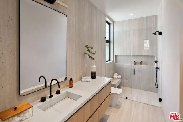 a bathroom with a sink and mirror with toilet