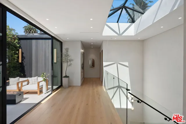 a view of hallway with furniture and a chandelier