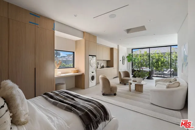 a bedroom with a bed and large windows