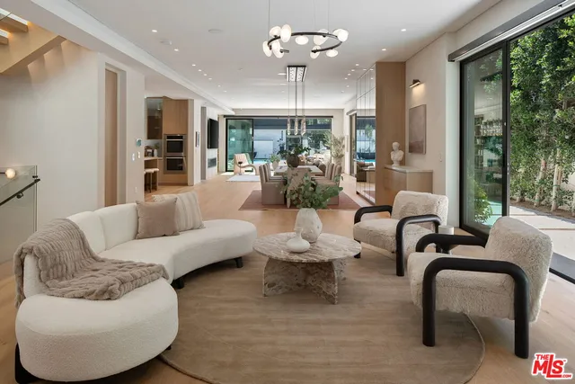 a living room with furniture potted plant and a large window
