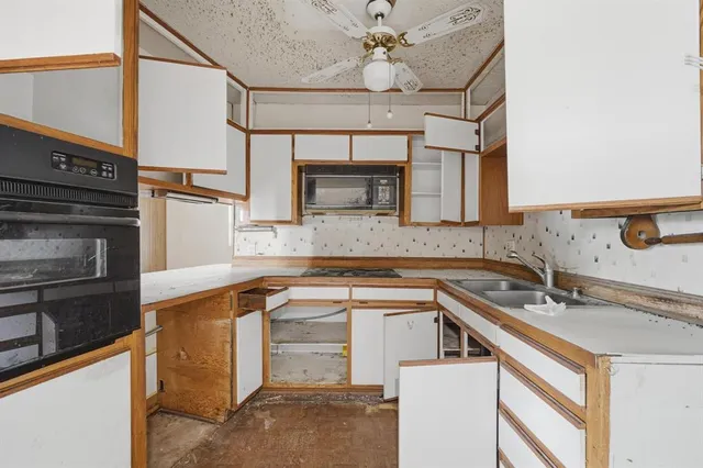 a kitchen that has a sink and a stove top oven