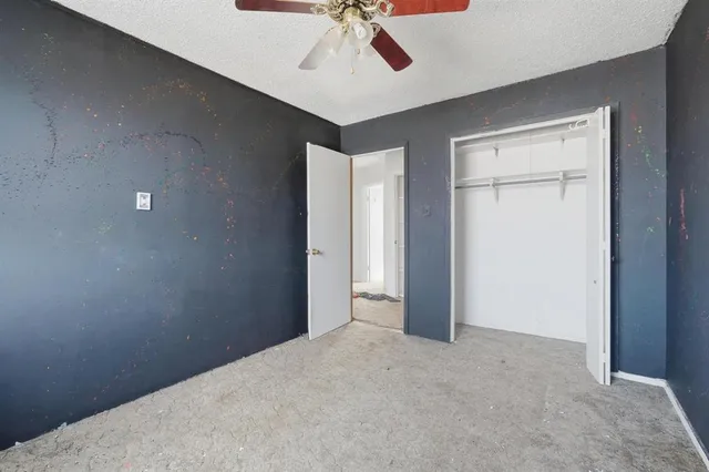 a view of a livingroom with a ceiling fan and kitchen space