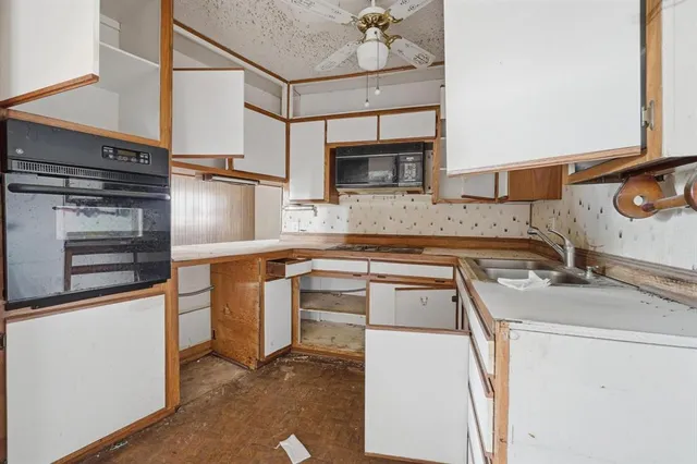 a kitchen with appliances a sink and cabinets