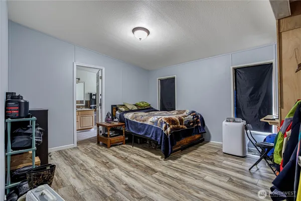 a bedroom with a bed and a flat tv screen on the dresser
