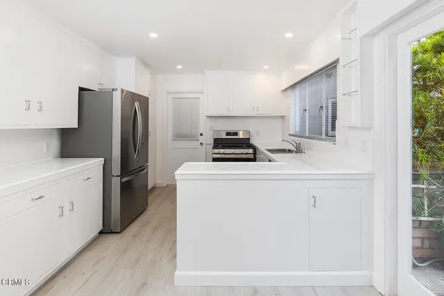 a kitchen with a refrigerator sink and cabinets