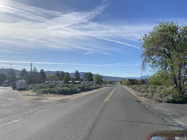a view of a dry yard with wooden fence