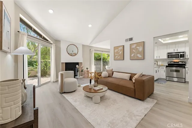 a living room with furniture a fireplace and a large window