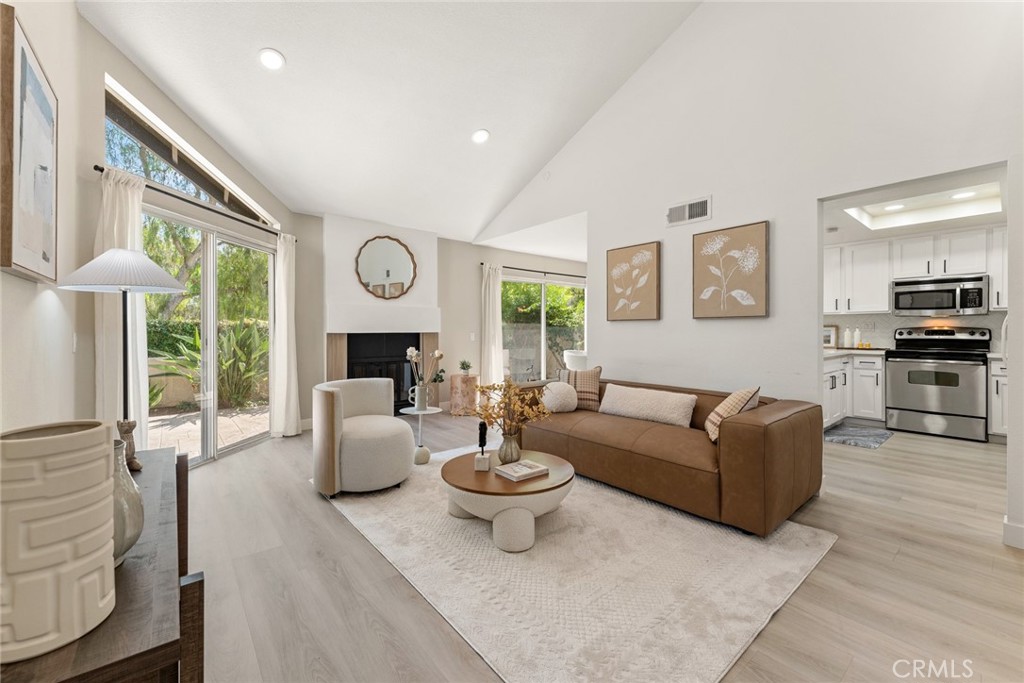a living room with furniture a fireplace and a large window