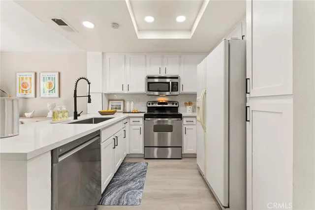 a kitchen with stainless steel appliances granite countertop a refrigerator and a stove top oven