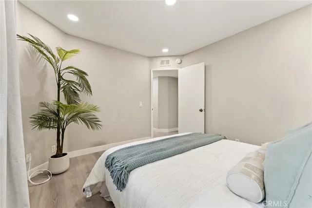 a bedroom with a bed and a potted plant