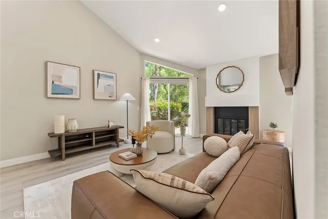 a living room with furniture a fireplace and a large window