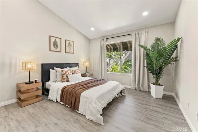 a spacious bedroom with a large bed and a potted plant