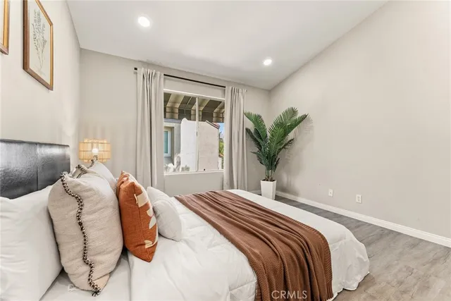 a bedroom with a large bed and a potted plant