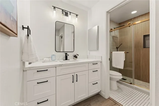 a bathroom with a double vanity sink mirror and toilet