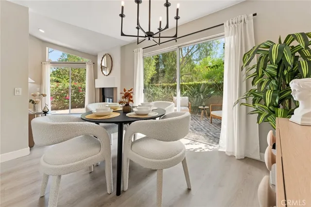 a dining room with furniture a chandelier and a large window