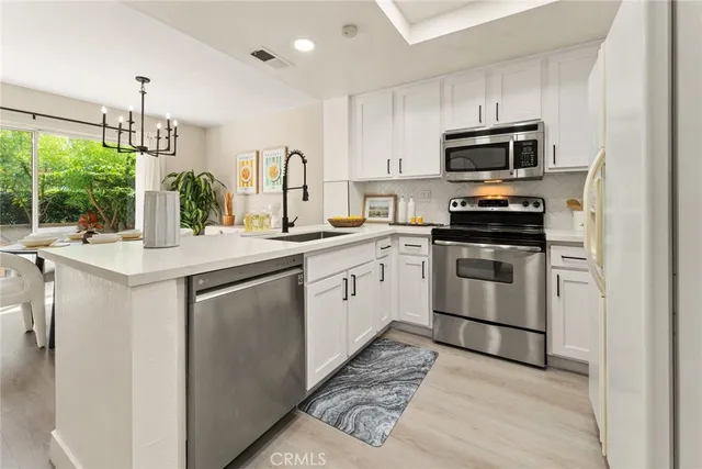 a kitchen with white cabinets appliances and a sink