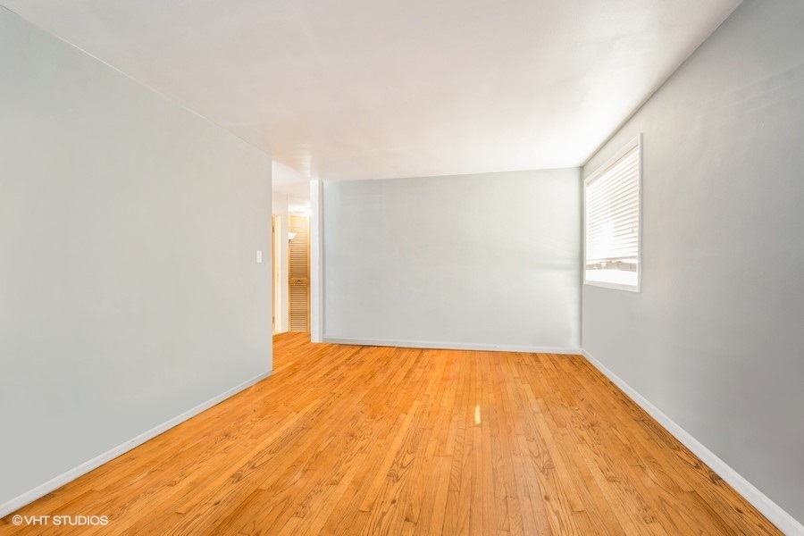 1925 Harrison Street, Unit 3H Evanston, IL 60201 - Photo 4 of 9 a view of empty room with wooden floor and fan