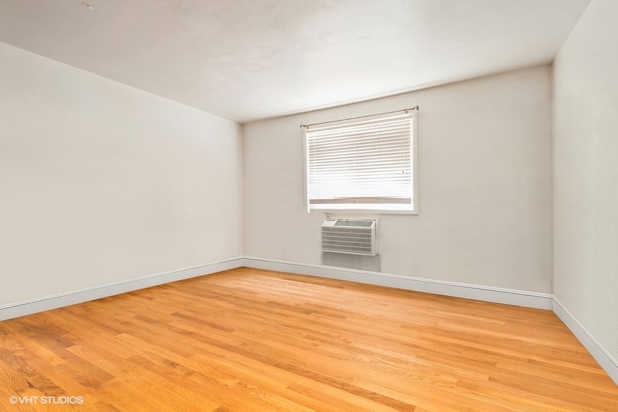 1925 Harrison Street, Unit 3H Evanston, IL 60201 - Photo 5 of 9 an empty room with wooden floor and windows