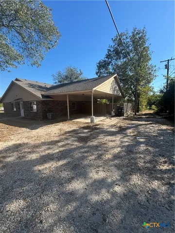 a front view of house with yard and trees around