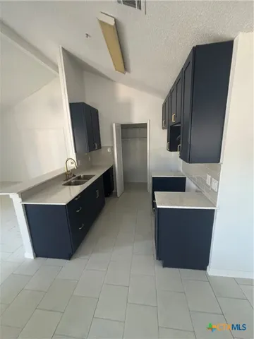 an empty room with a chandeliers fan