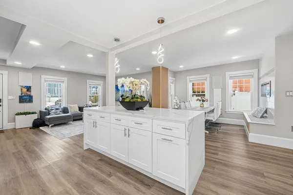 a large white kitchen with lots of counter top space and living room
