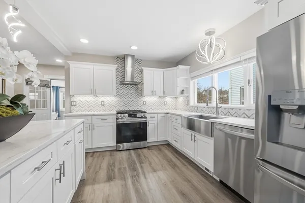 a large kitchen with stainless steel appliances and white cabinets