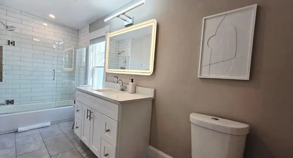 a bathroom with a double vanity sink toilet and shower