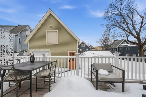 a view of a house with a wooden deck and furniture