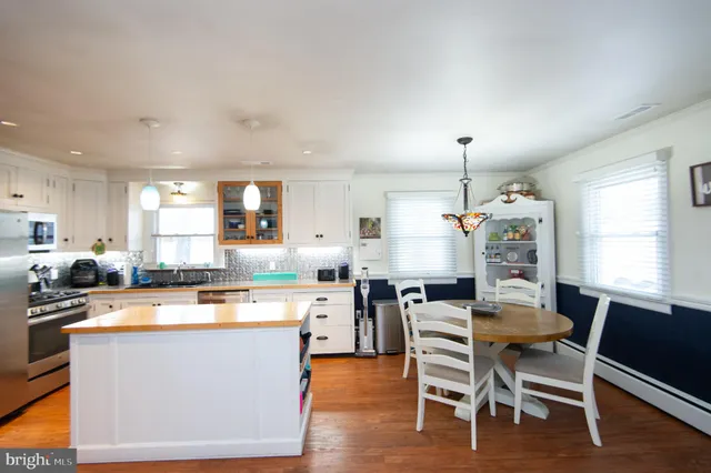 a kitchen with a dining table chairs and refrigerator