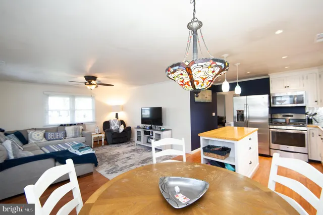 a living room with furniture a dining table and a chandelier