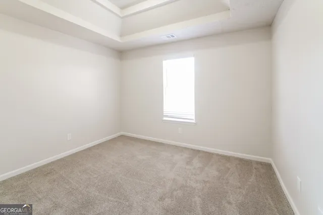 an empty room with a white cabinet and a window