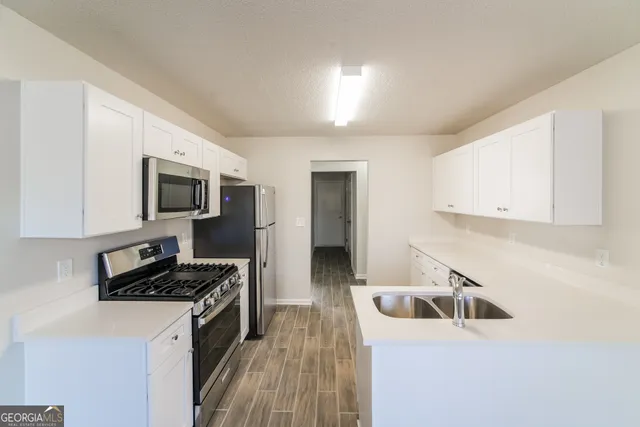 a kitchen with a sink a stove and cabinets