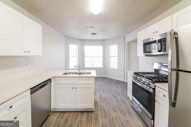 a kitchen with stainless steel appliances a sink stove and cabinets