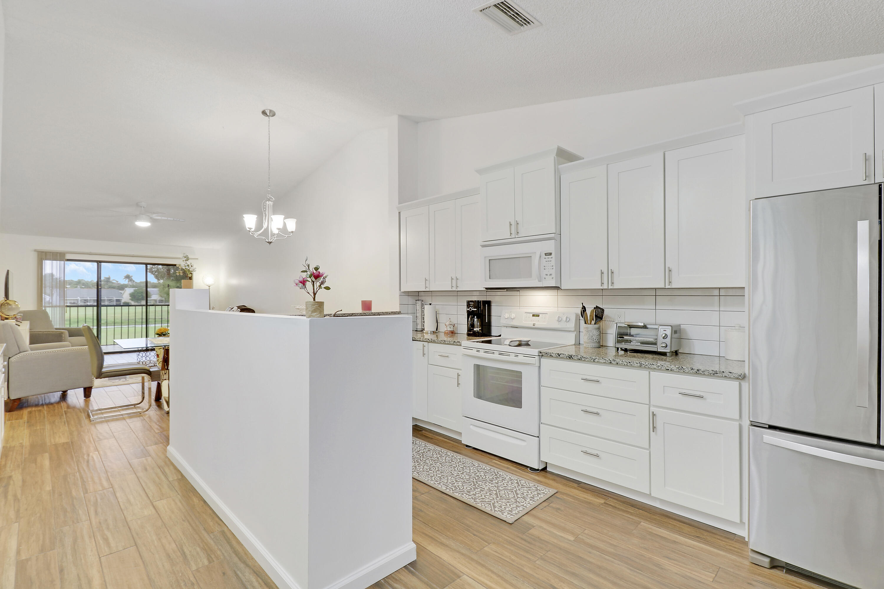 1112 Keystone Drive, Unit A Jupiter, FL 33458 - Photo 18 of 41 a kitchen with white cabinets and white appliances