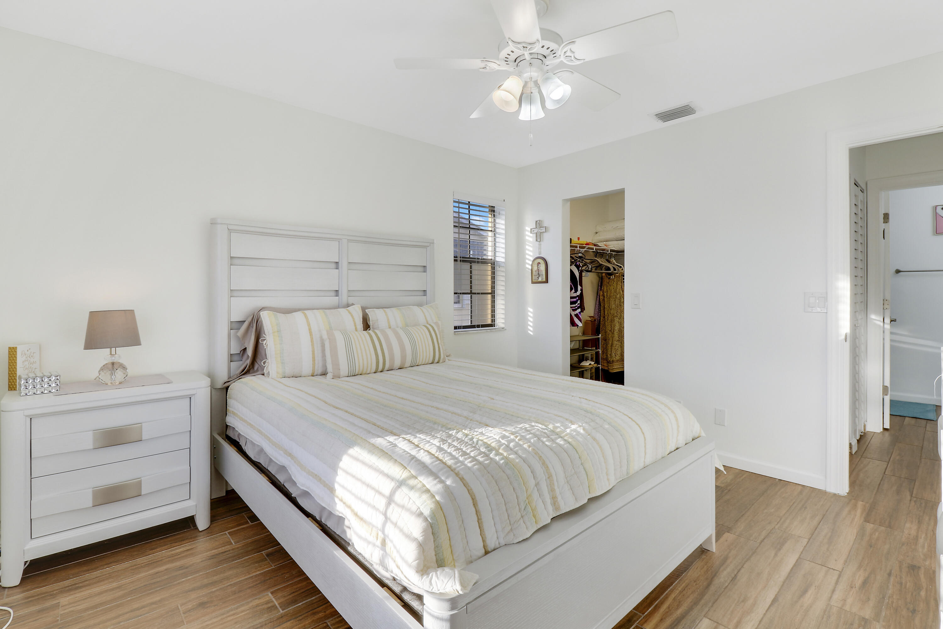 1112 Keystone Drive, Unit A Jupiter, FL 33458 - Photo 23 of 41 a bedroom with a large bed and a chandelier