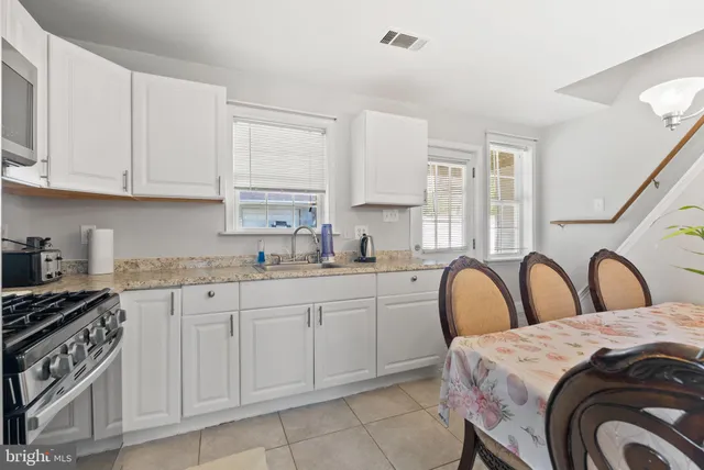 a kitchen with white cabinets a sink and appliances