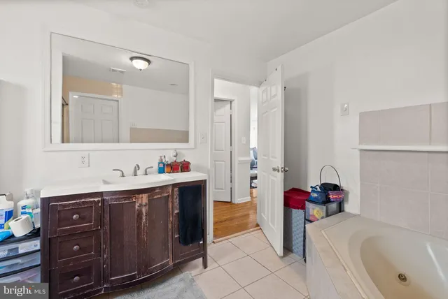 a bathroom with a tub sink and a mirror
