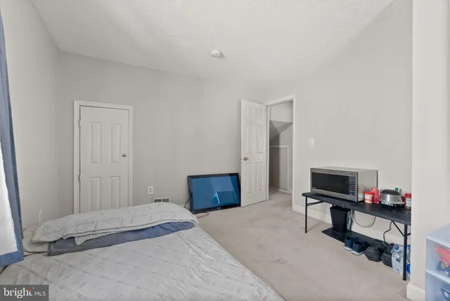 a bedroom with a bed and a computer on a table