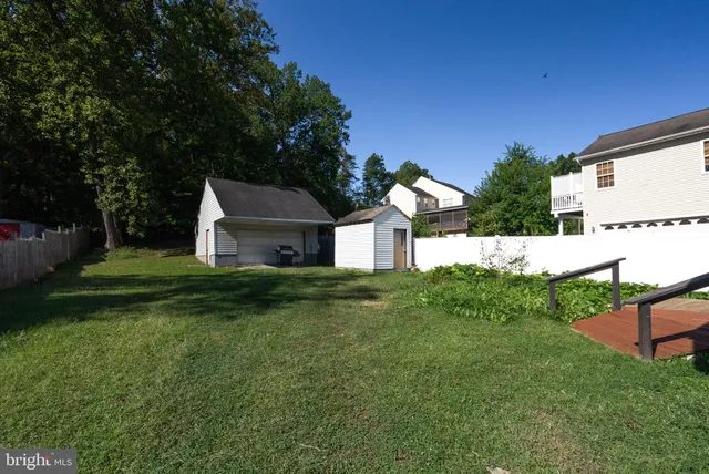 a view of a house with a big yard potted plants and large tree