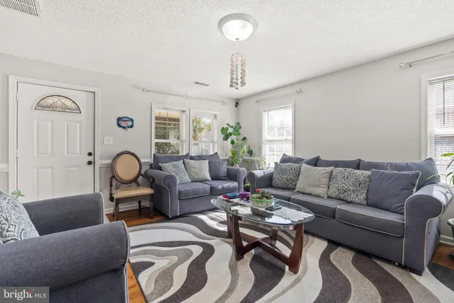 a living room with furniture a chandelier and a rug
