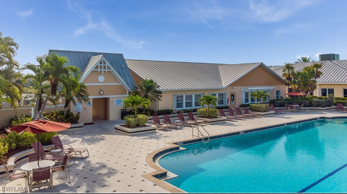 1927 Nottingham Trail Punta Gorda, FL 33980 - Photo 31 of 35 a view of a swimming pool with lawn chairs under an umbrella